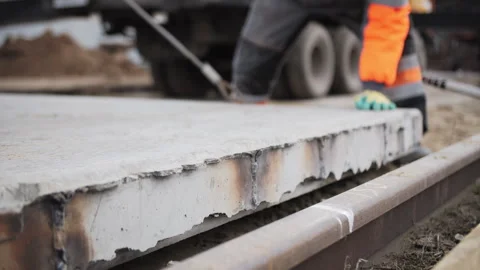 Worker guiding concrete slab during installation at construction site Stock Footage 310950992