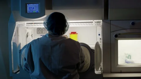 Worker in Hairnet Operating Sterile Isolator, Hospital Pharmacy, Rear View Shot Stock Footage 341333157