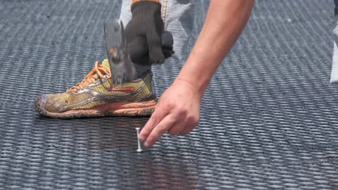 Worker hammer down the dowel into asphalt to fix the reinforcing mesh Stock Footage 134130098