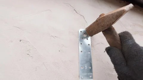 Worker hammering dowel nail into plaster wall 스톡 동영상 335280434