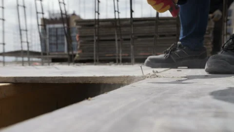 Worker hammering nail on construction formwork Stock Footage 314058999