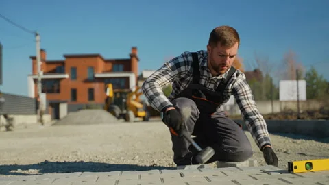 Worker Hammering Paving Stones at Construction Site Stock Footage 297791772