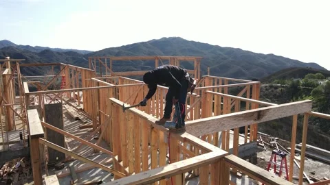 Worker hammering on top of framing at a construction yard Stock-Footage 228794793
