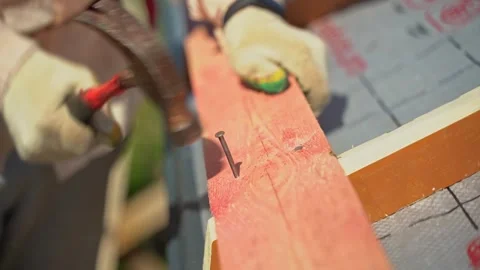 A worker hammers nails into boards close-up. Roof sheathing Stock Footage 265075933