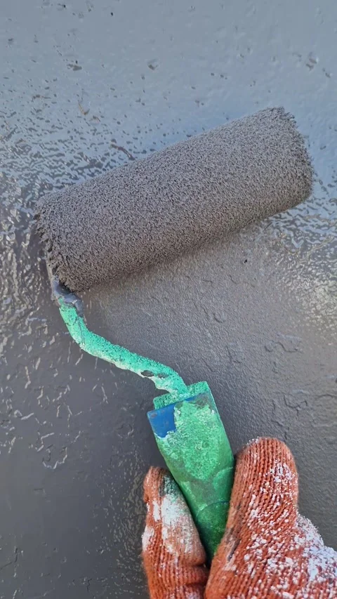 Worker Hand Applying Grey Paint Roller on Textured Wall Stock Footage 318362698