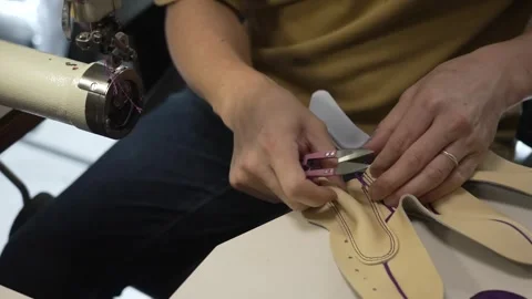 Worker hand assembling a leather glove with a purple accent at the sewing Stock Footage 340276666