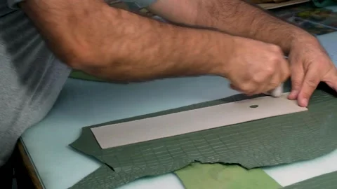 Worker Hand Cutting Green Leather Piece with Pattern Template Stock Footage 322057698