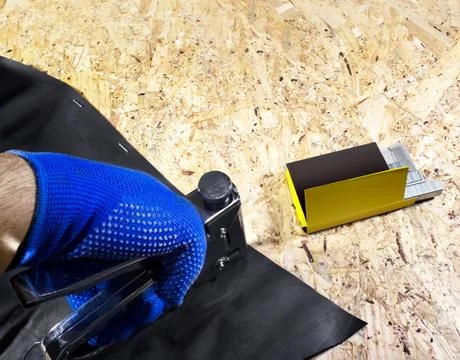 Worker hand in gloves using stapler. Stock Photos