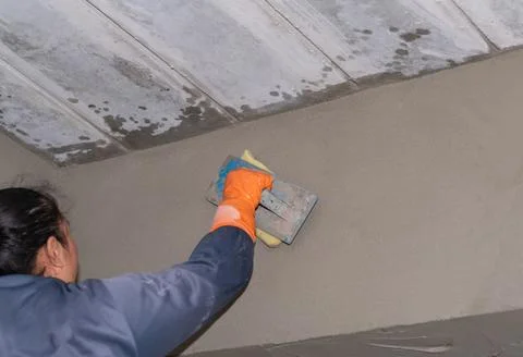 Worker hand holding plastering tool inside wall. Foto stock