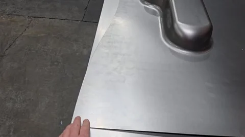 Worker hand pointing at formed metal sheet during car part manufacturing process 스톡 동영상 332603689