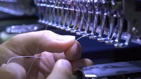 A worker hand put in thread on needle at Garment Manufacturers Stock Footage 106790808