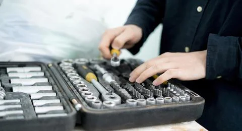 A worker hand taking the tool from the set case to do make the project Stock Photos