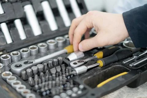 A worker hand taking the tool from the set case to do make the project Stock Photos