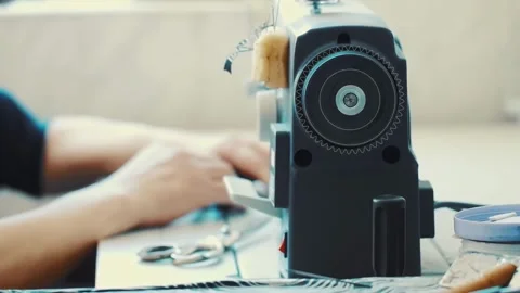 Worker hand works on a sewing machine and controls the stitching process Stock Footage 258379570