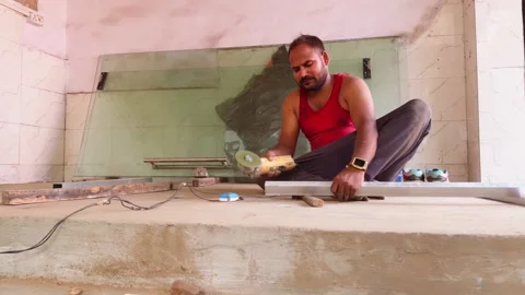 Worker handles metal slab using electric saw Stock Footage 312385886
