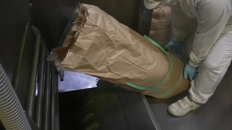 Worker Handling a Sack of Processed Tea on a Chute Stock Footage 340009777