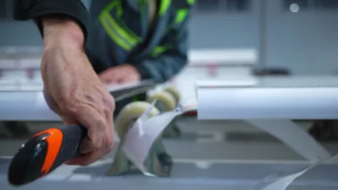 Worker hands cut foil leftovers between plastic profile sheets Video stock 304429296