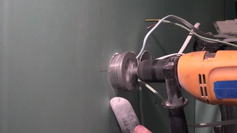 Worker hands with drill drilling round hole in drywall plasterboard Stock Footage 117266718