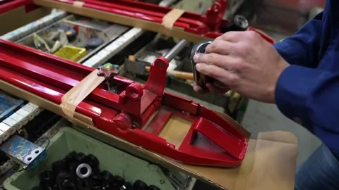 Worker hands installing black roller wheel onto red pallet truck fork 스톡 동영상 347719706