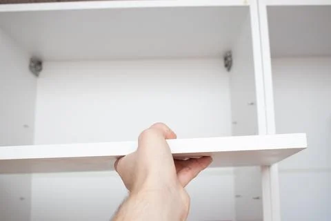 A worker hands installing a shelf in kitchen drawers on the wall Fotos de archivo