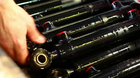 Worker hands sorting oiled shock absorber rods. Closeup metal parts factory. Stock Footage 345678839