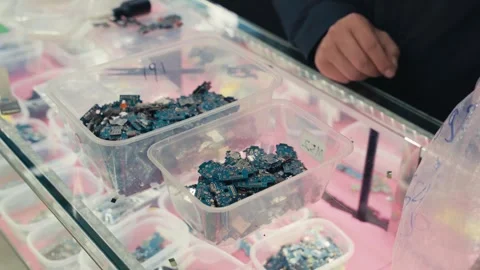 Worker hands sorting smartphone circuit boards in electronics workshop Stock Footage 328956080