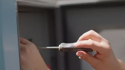 Worker Hands Using Screwdriver to Open Metal Cabinet Door Stock Footage 336522560