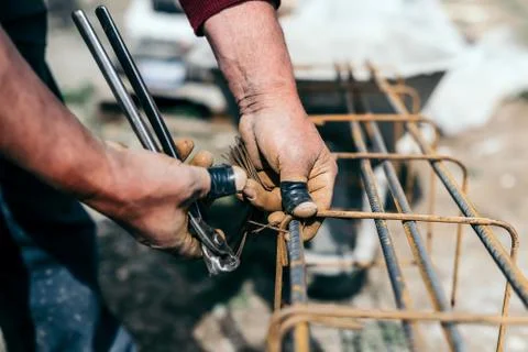 Worker hands using steel wire and pincers to secure steel bars Stock Photos