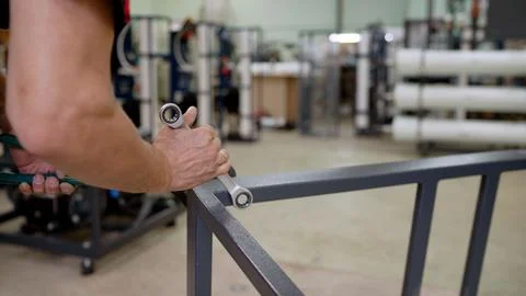 Worker hands using a wrench to assemble a metal frame in a factory Stock-Fotos
