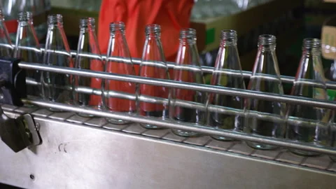 Worker hands wearing gloves placing empty glass bottles on industrial autom.. Stock Footage 337755608