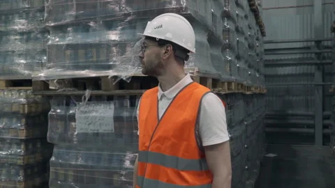 Worker in a hard hat enjoying the warehouse supervisor job at the factory Stock Footage 241397823