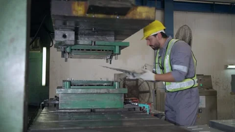 Worker in hard hat operates heavy press machine Stock Footage 346153136