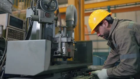 Worker in hard hat operates heavy industrial machine Stock Footage 346268743