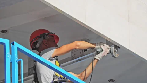 Worker with hardhat cuts metal beam edge with disc saw Stock-Footage 243812171