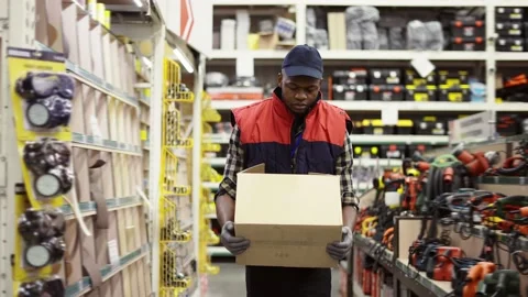 Worker in hardware store carrying box Stock Footage 172016916