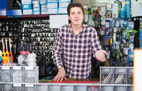 Worker in hardware store trading goods for water tap in uniform Foto stock