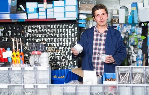 Worker in hardware store is trading sockets Foto stock