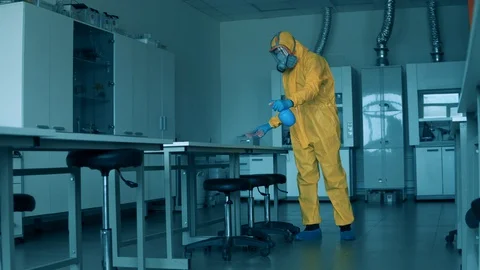 Worker in a hazmat suit is cleaning surfaces in the laboratory Stock Footage 129392636