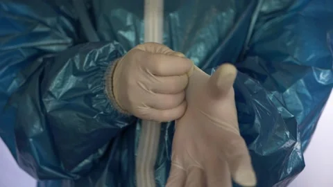 Worker in hazmat suit donning protective gloves Stock Footage 157176870