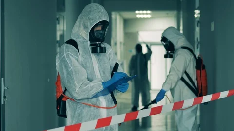 Worker in a hazmat suit is inspecting the disinfection process Stock Footage