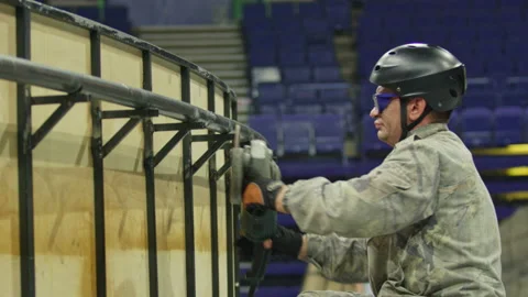 Worker with helmet and goggles grinds steel handrail of pool Stock Footage 238936182