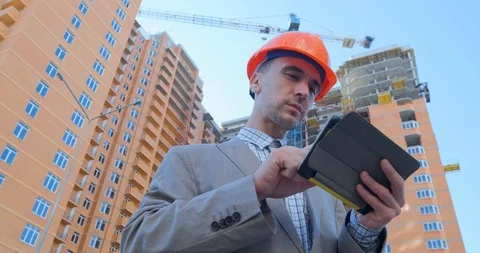 Worker in helmet near the construction yard Stock Footage 116030177