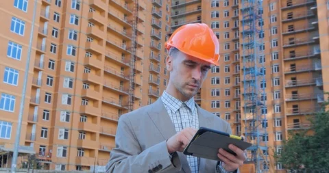 Worker in helmet near the construction yard Stock Footage 116030188