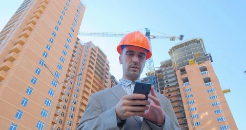 Worker in helmet near the construction yard Stock Footage 116030384
