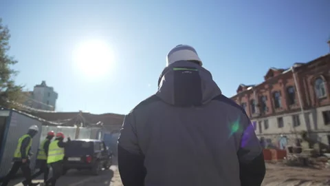 Worker in helmet walks construction site under sunny sky Stock Footage 314887138