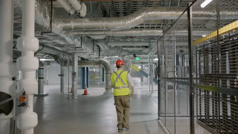 Worker in helmet walks through factory Stock Footage 138907863