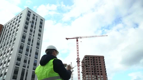 A worker in a helmet watching a construction site Video stock 164901865