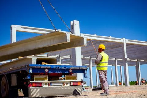 Worker is helping crane to keep balance and direction with rope Stock Photos