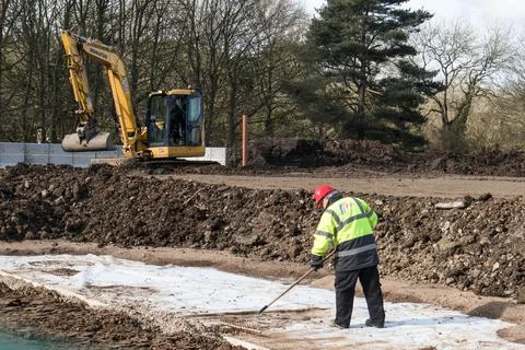 Worker in high vis jacket and hard hat on a construction site. Stock Photos