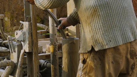 The worker, with his bare hands, takes out a dirty hose from a pipe. Stock Footage 122324472